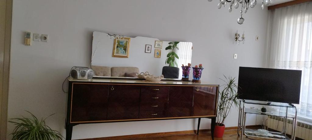 a living room with a dresser and a television at 7 Flower Street Apartment in Šempeter pri Gorici