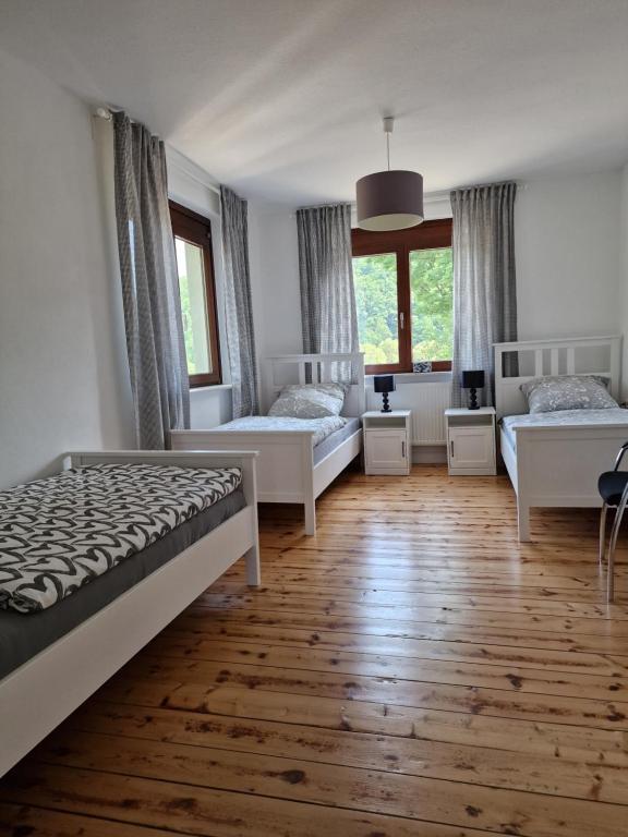 um quarto com 2 camas e 2 janelas em Lindenwohnung an historischer Mühle em Holzhausen