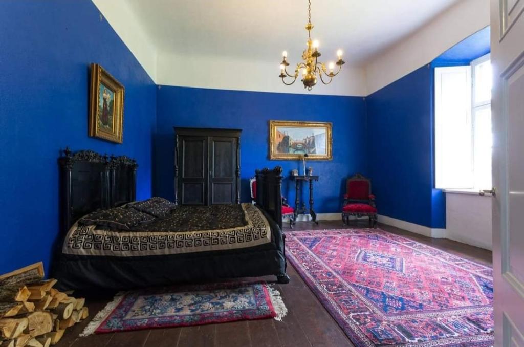 um quarto azul com uma cama e um lustre em Rava möis em Rava