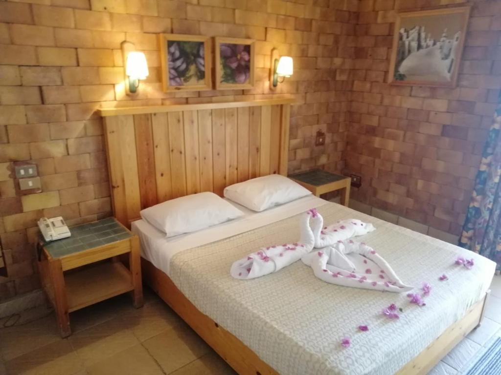 a bedroom with a bed with two shoes on it at Tobya Village Hotel in Taba