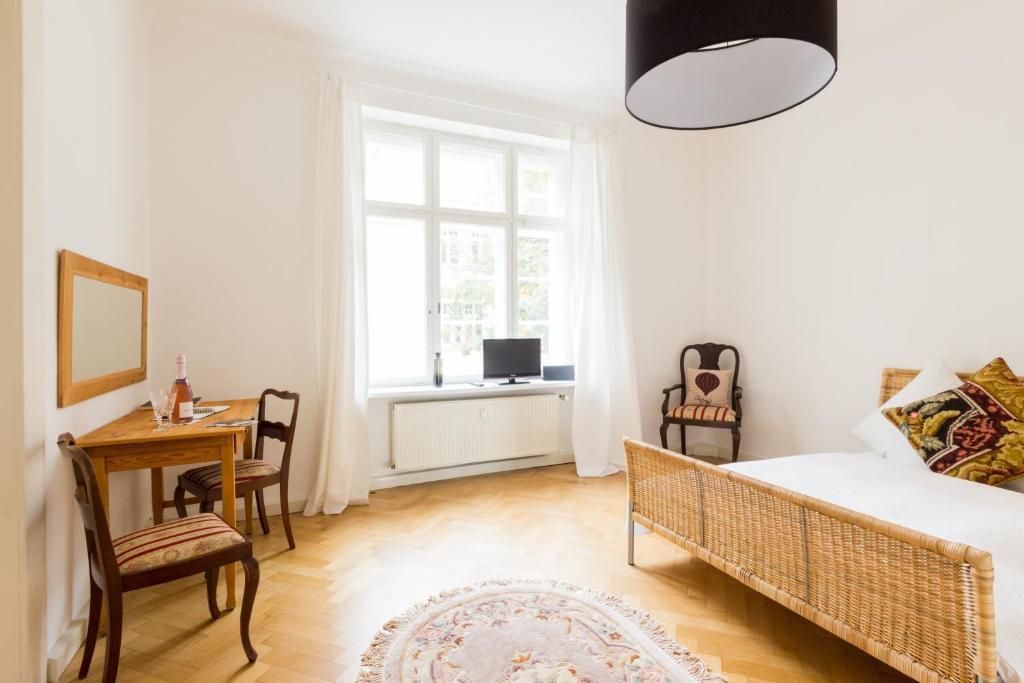um quarto com uma cama, uma secretária e uma janela em Ferienwohnung in Altstadtnähe em Weimar