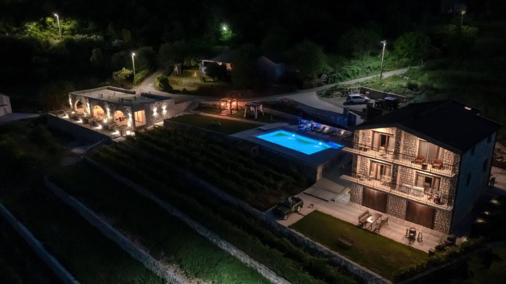 an aerial view of a mansion at night with a swimming pool at Apartments and Winery Djukovic in Virpazar