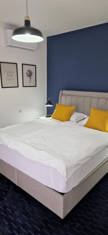 a large bed with yellow pillows in a room at Sobe Majetic in Bizovac