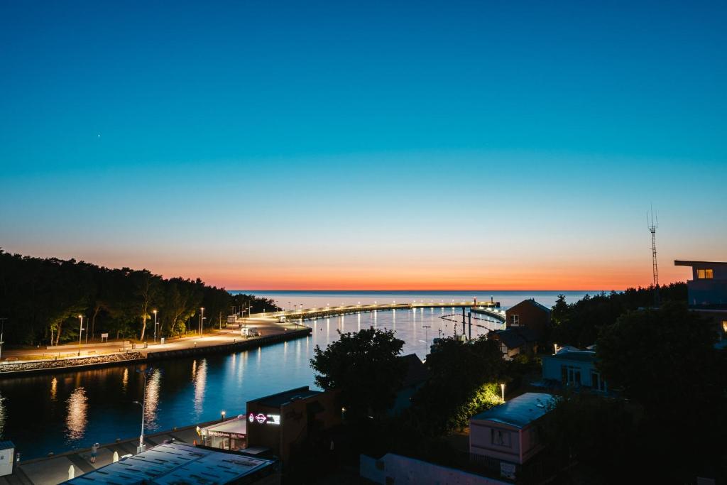 - une vue sur un pont sur une rivière au coucher du soleil dans l'établissement Art Boulevard, à Mrzeżyno