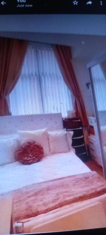 2 bedrooms, 2 bathrm Leicester City Apartment, Central Location, sleeps 2 في ليستر: غرفة نوم بسرير كبير عليها شراشف ووسائد بيضاء