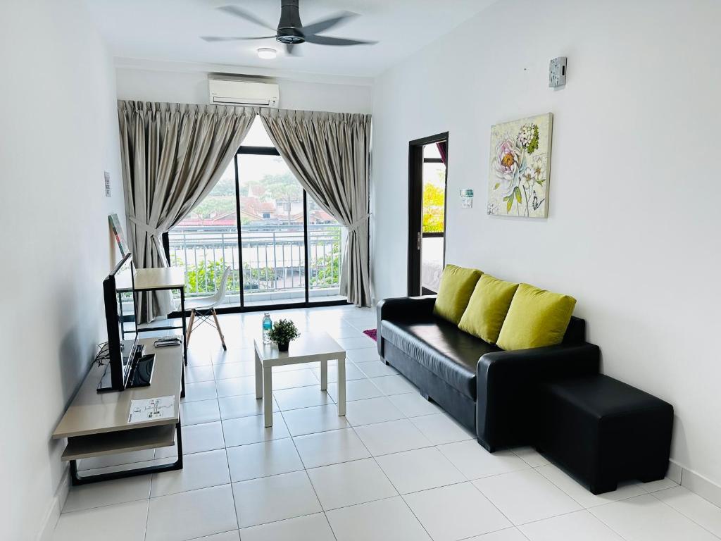 sala de estar con sofá negro y ventana en J&R Homestay Johor Bahru near Austin Southkey CIQ Singapore, en Kangkar Teberau