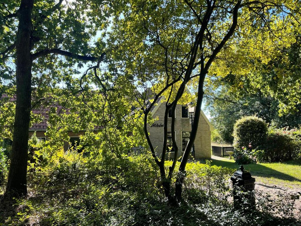 a fire hydrant in front of a house with trees at Spacious Country Retreat in Den Burg