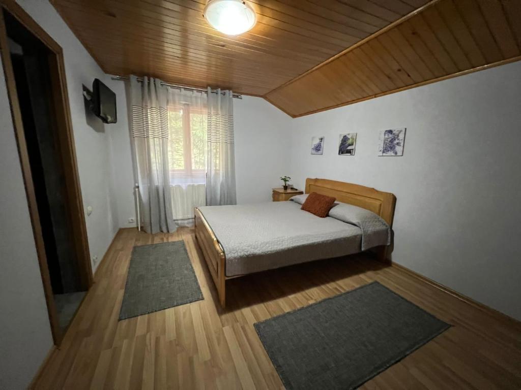 a bedroom with a bed and a television in it at Pensiunea Lu' Movila in Durau