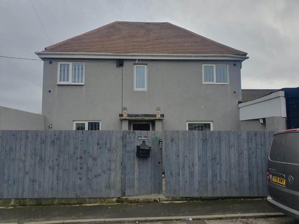 a white house with a wooden fence and a van at The hawthorns large detached 3 bedroom family home in Seaham