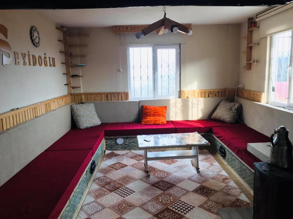 a living room with a red couch and a table at Trabzon Uzungöl dağ evi in Trabzon