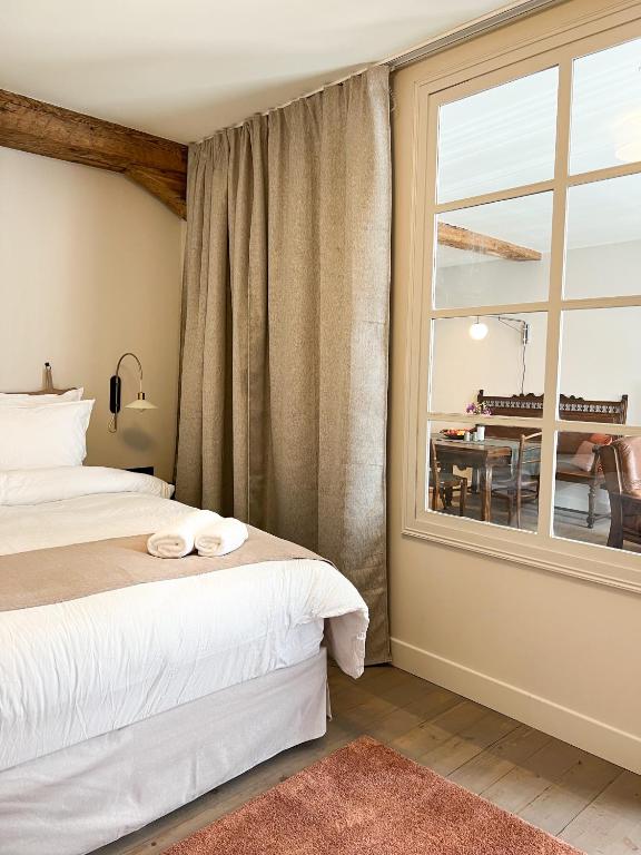 Hotel Le Baumann Concept: Appartement de Charme dans un Monument Historique, a bedroom with two beds and a window at Le Baumann Concept: Appartement de Charme dans un Monument Historique in Colmar