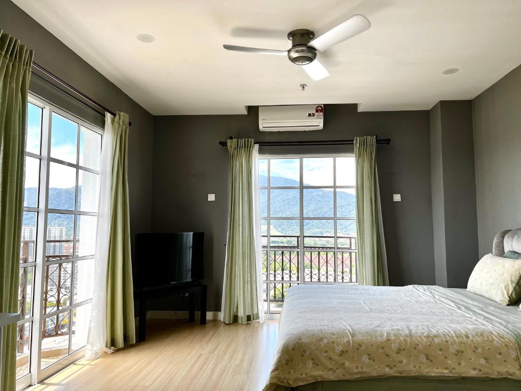 a bedroom with a bed and a television and windows at Netflix l Chill Studio Kampar Champs Élysées in Kampar