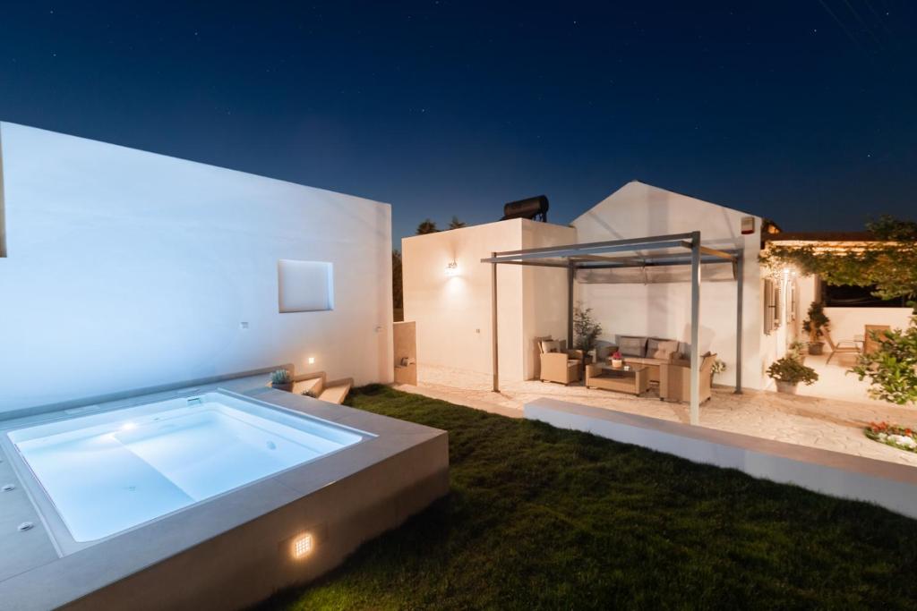 a backyard with a swimming pool at night at Van Loui's II Place in Áyioi