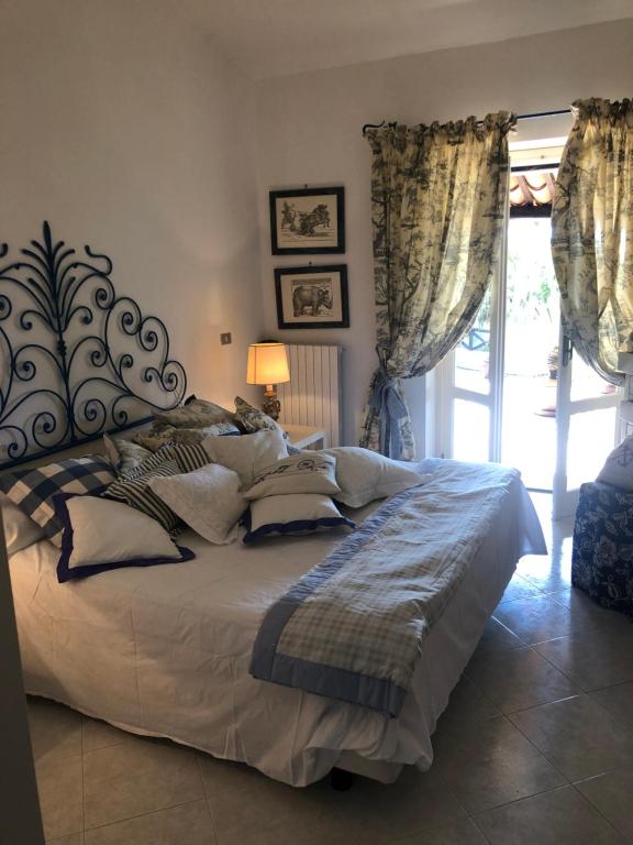 Un dormitorio con una cama grande y una ventana en Esclusiva villa sul mare Tropea, en Parghelia