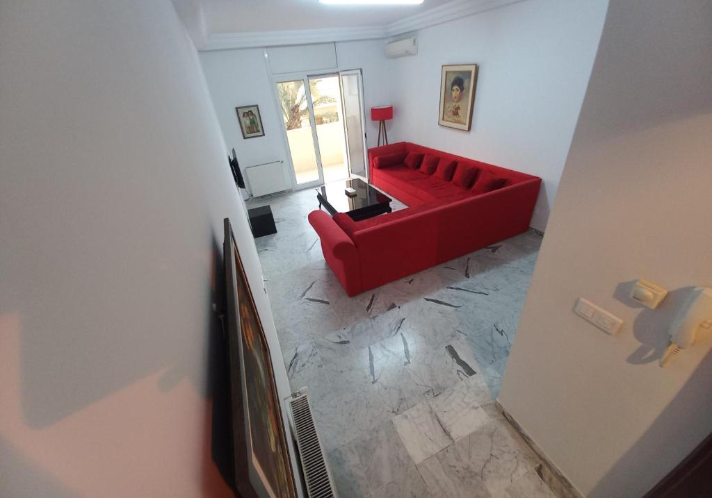 een woonkamer met een rode bank in een kamer bij Cozy Inn Lac 2 in Tunis