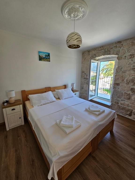 a bedroom with a large bed and a window at APARTMAN ELI in Supetar