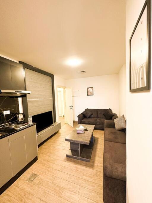ein Wohnzimmer mit einem Sofa und einem Tisch in der Unterkunft central apartment for rent 26 in Umm Uthainah