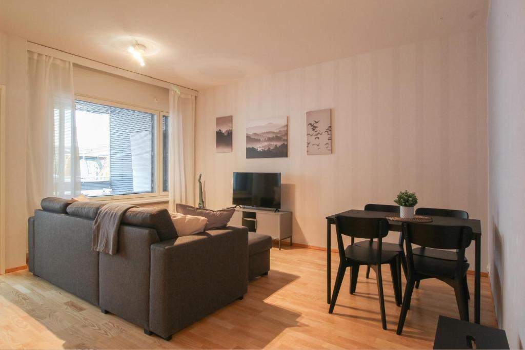 een woonkamer met een bank en een tafel bij City Apartment Satamantupa in Kuopio