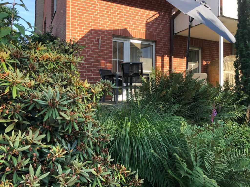 a brick house with chairs and plants in front of it at Ferienhof Kröger in Bielefeld