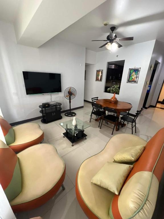 a living room with couches and a television and a table at Spacious 3BR Manhattan Parkview Tower 2 in Manila