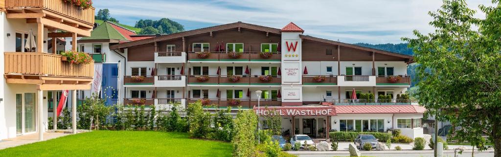 ニーデラウにあるHotel & Alpin Lodge Der Wastlhofの緑の芝生が目の前に広がる大きなホテル