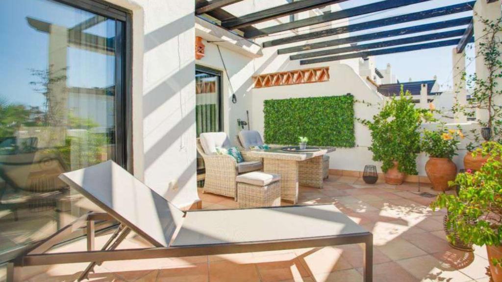 d'une terrasse avec une table et des chaises sur un balcon. dans l'établissement Sunset Golf Urbanisation - La Rasina Golf and Country Club, à Estepona