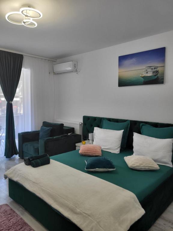 uma sala de estar com uma cama verde e um sofá em Garsoniera Ady em Mangalia