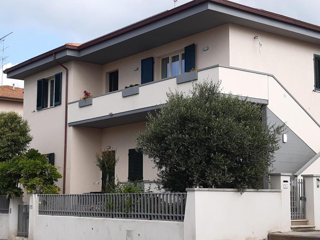 een wit huis met blauwe luiken erop bij Casa Dino in Rosignano Solvay