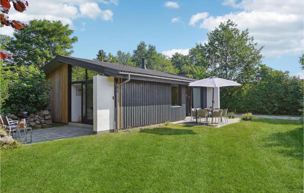 ein kleines Haus mit Sonnenschirm und Rasen in der Unterkunft Nice Home In Odder With Wifi in Odder