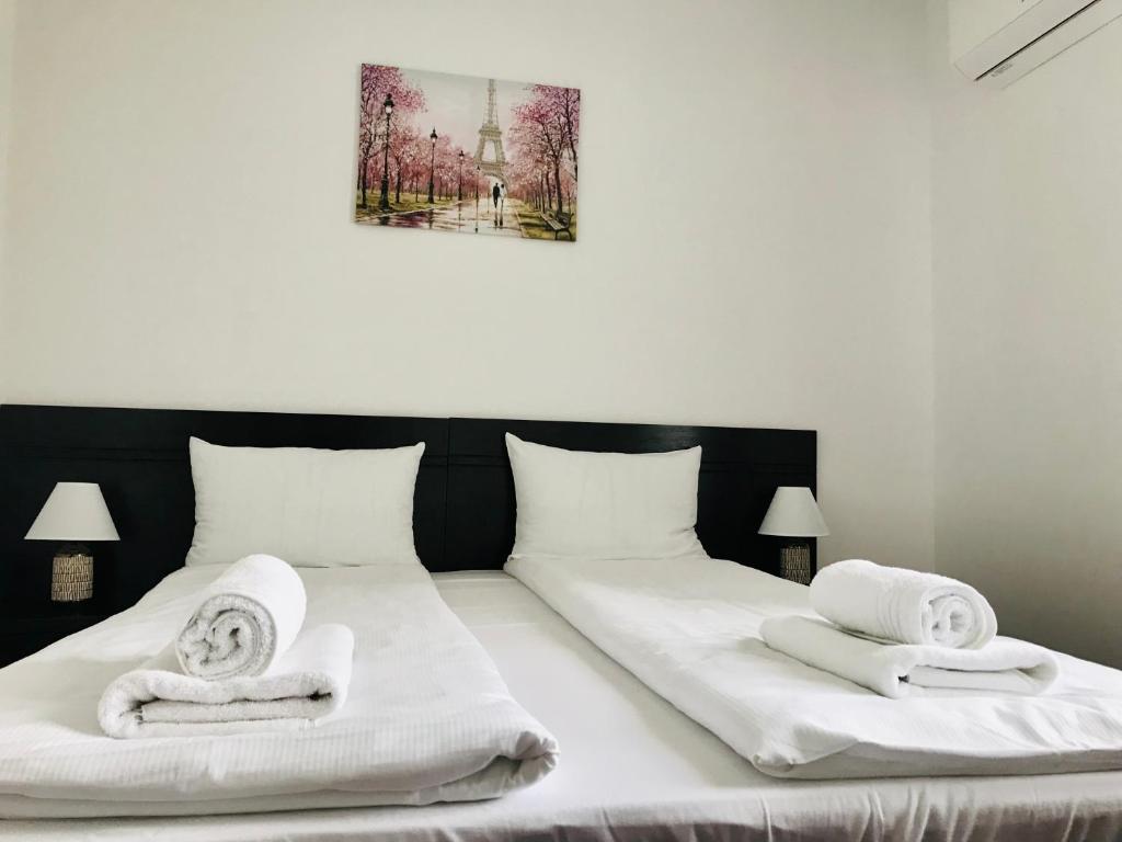 een slaapkamer met 2 bedden en handdoeken bij Apartamente 9 - Naomi in Baile Felix