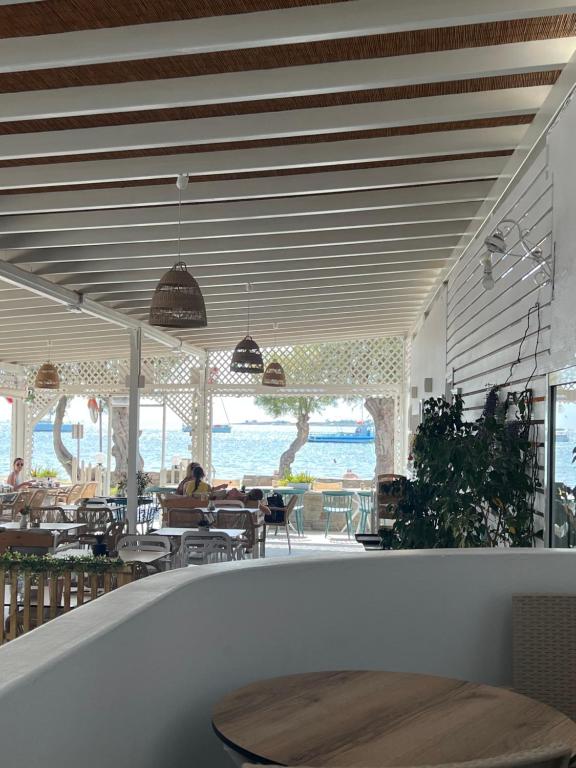 帕羅奇亞的住宿－Kirki Rooms by the sea，一间设有桌子的餐厅,有坐在桌子上的人