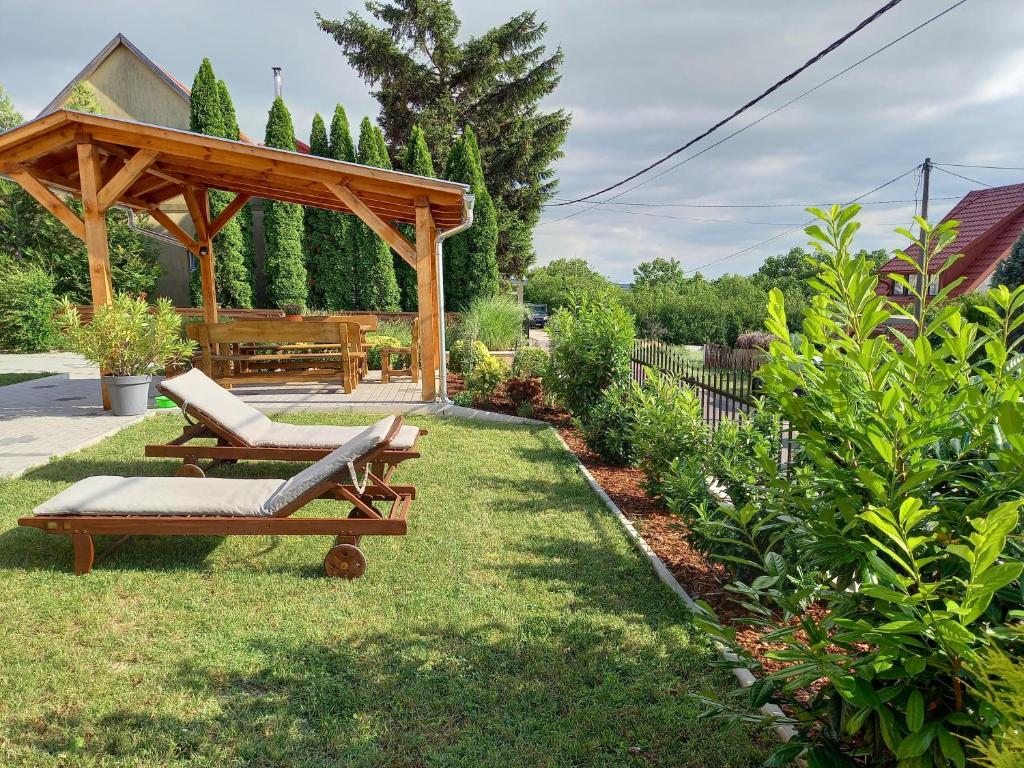 a wooden gazebo with two chairs and a bench at Laura-haus in Vonyarcvashegy