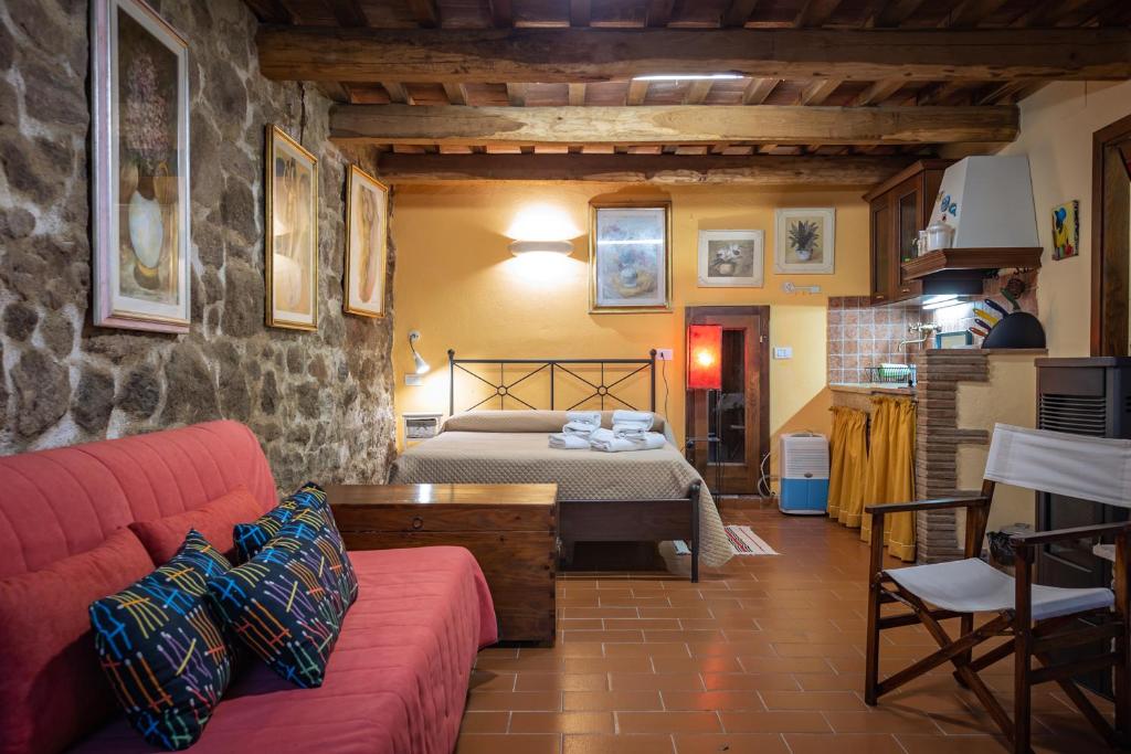 sala de estar con cama y sofá rojo en Santa Fiora Ospitalità Diffusa - Il Nido, en Santa Fiora