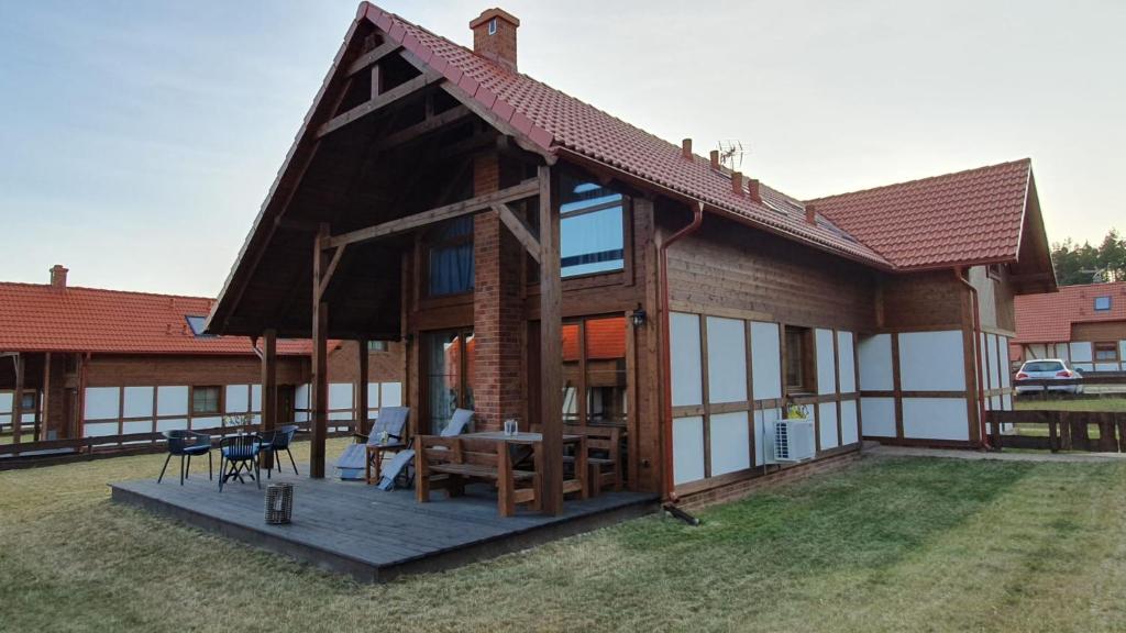 a house with a large deck with a table at Szara Czapla in Borowy Młyn