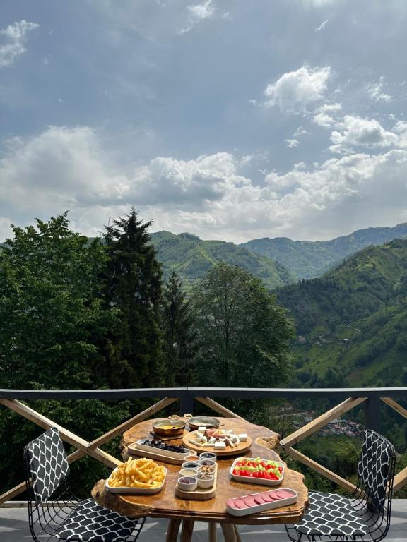 a table with plates of food on a balcony at Nova bungalov in Çamlıhemşin