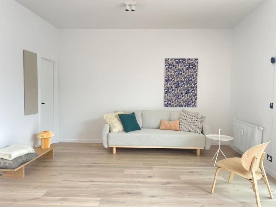 uma sala de estar com um sofá e uma mesa em #2800ourhome 201 em Mechelen