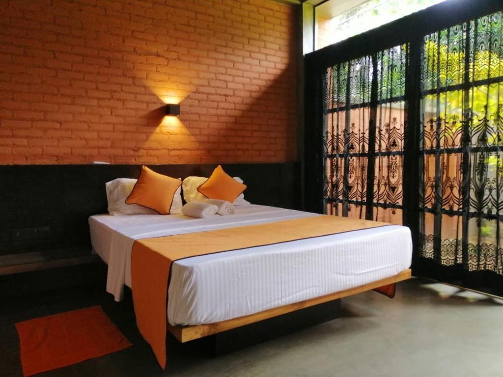 a bed in a room with a large window at Avera Hills Villas Unawatuna in Unawatuna