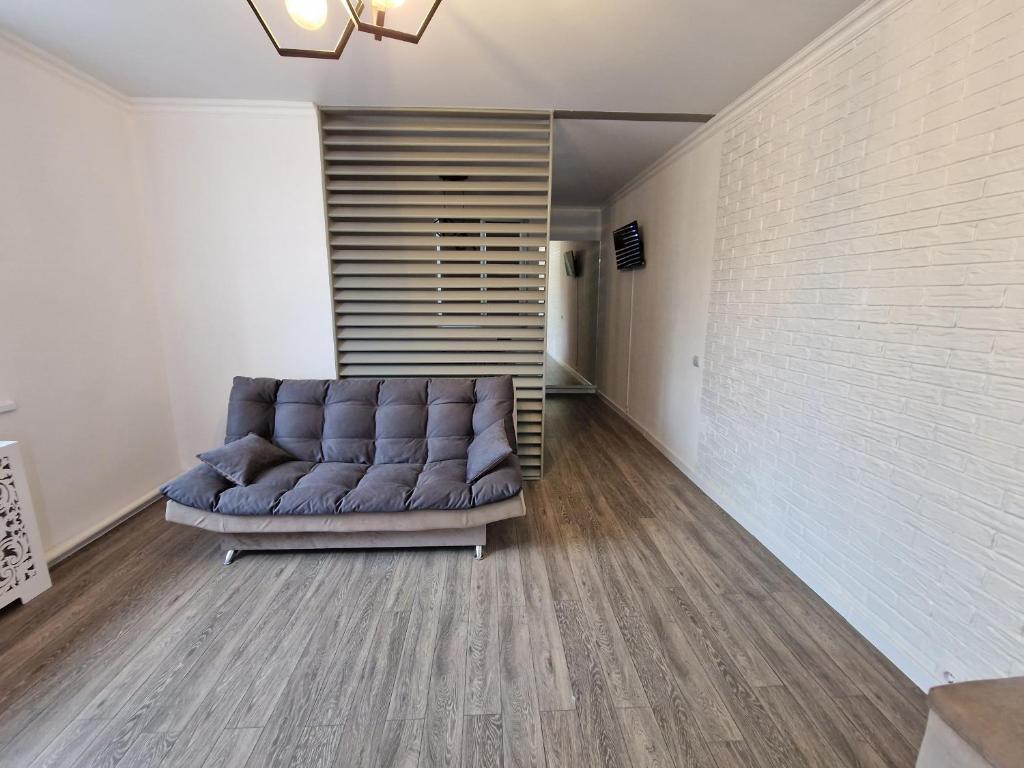 un sofá púrpura en una habitación con una pared de ladrillo en Apartament modern en Bălţi