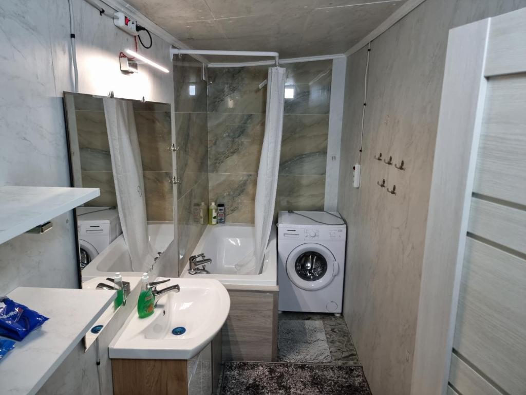 La salle de bains est pourvue d'un lavabo et d'un lave-linge. dans l'établissement Central rooms, à Chişinău