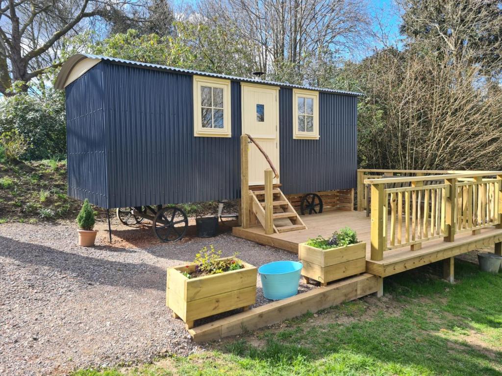 a tiny house sitting on a wooden deck at annes hatch hut 