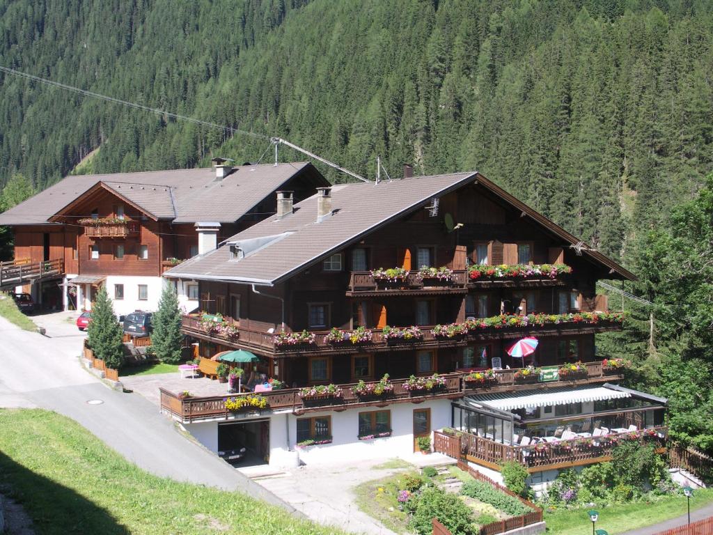 a large building with flowers on the balconies of it at Berggasthaus Trojen in Sankt Jakob in Defereggen