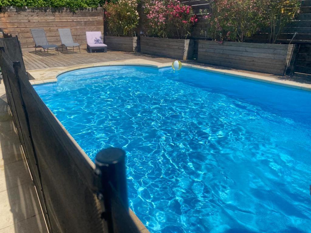 een zwembad met blauw water in een achtertuin bij Le Chant des Cigales in Le Cailar