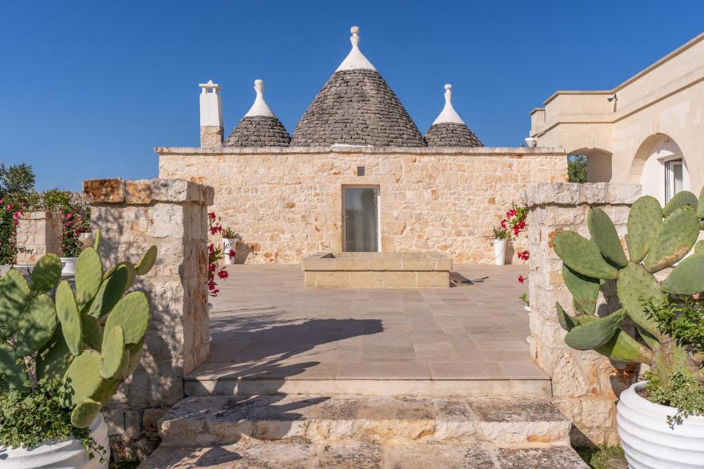 a stone building with a courtyard with cactus at Ostuni Dimore Aurea in Ostuni
