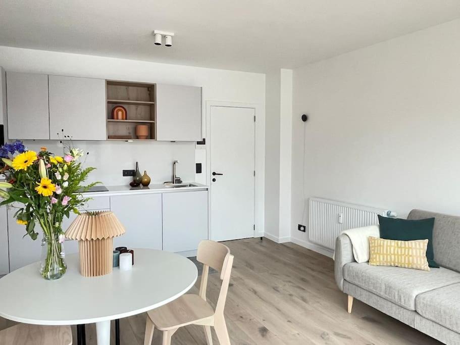 ein weißes Wohnzimmer mit einem Tisch und einem Sofa in der Unterkunft #2800ourhome 202 in Mechelen
