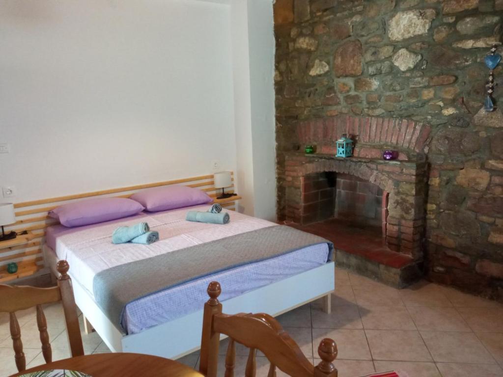 a bedroom with a bed and a stone fireplace at Traditional Stone House in Moudhros