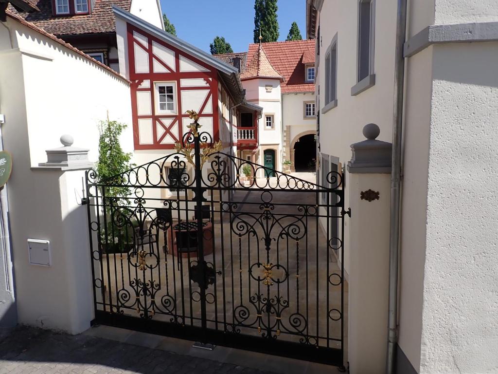 un cancello di ferro in un vicolo con una casa di Karlbacher Domizil Ferienwohnungen a Grosskarlbach