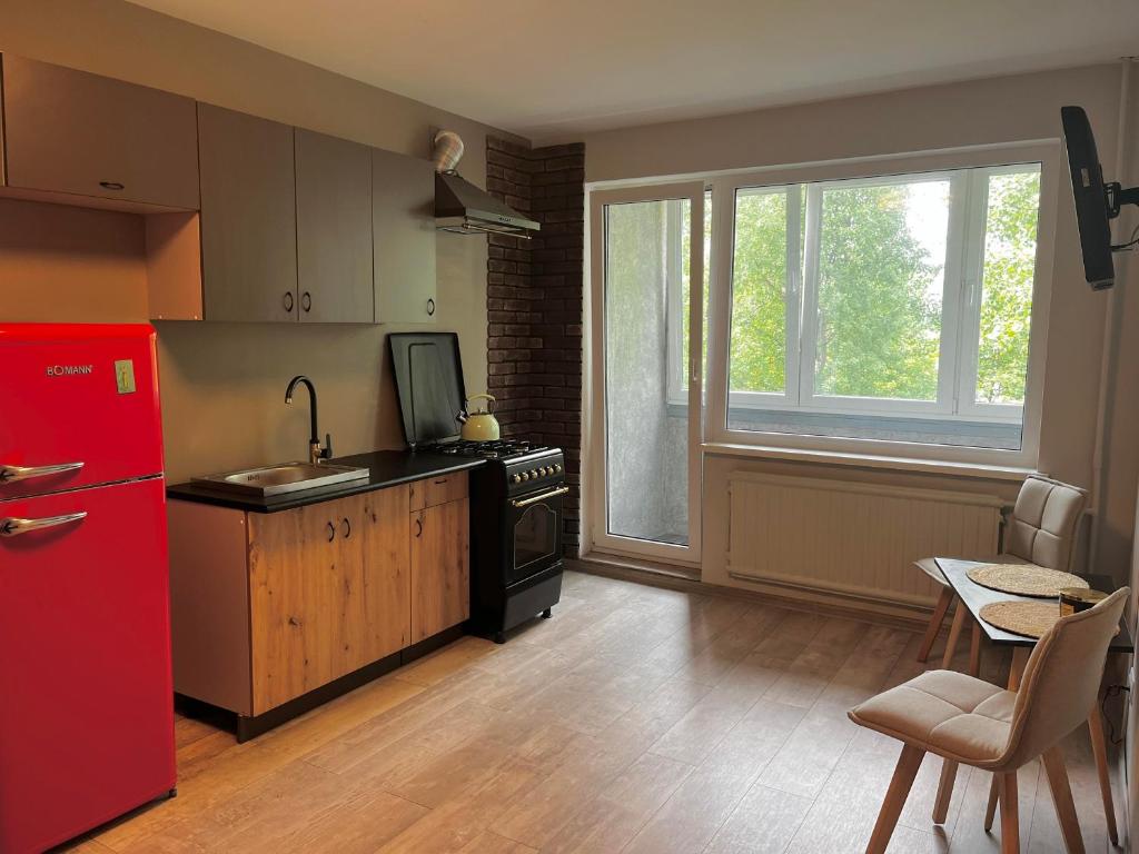a kitchen with a red refrigerator and a table at Lovely Stay in Siauliai in Šiauliai