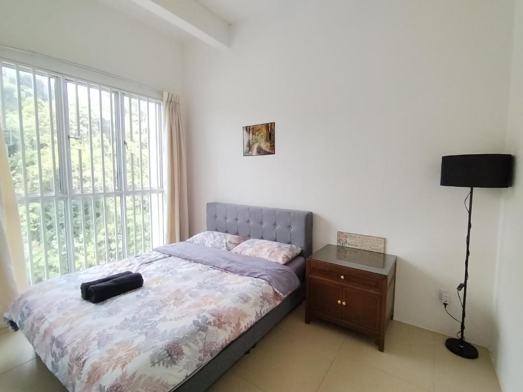 a bedroom with a bed and a large window at Daddy Homes Golden Hills pasar malam cameron 3bedroom in Brinchang