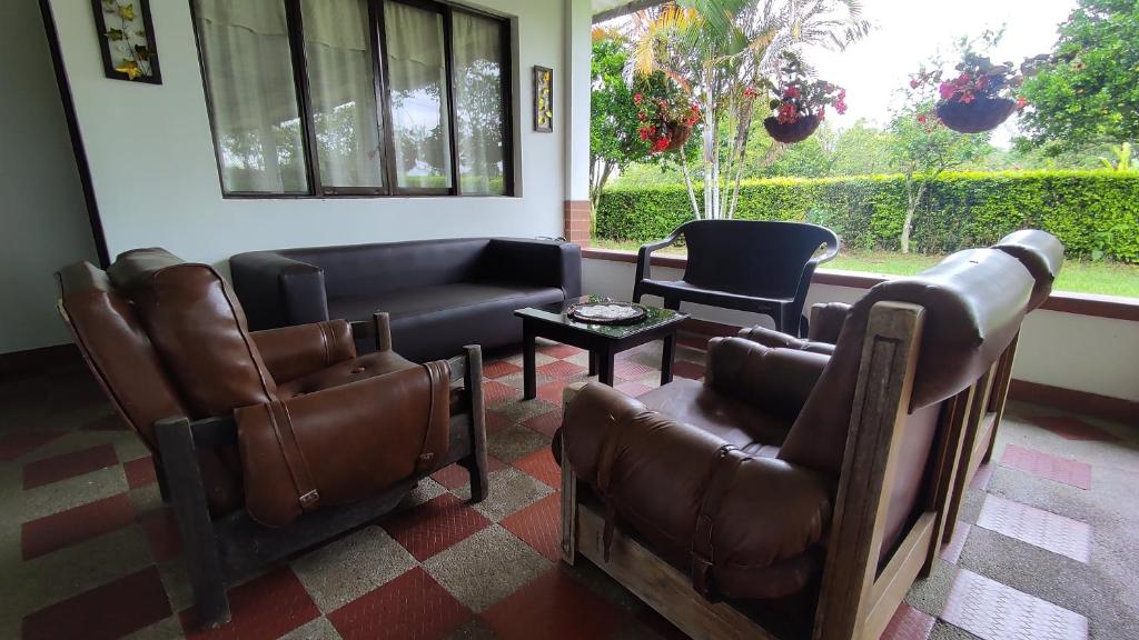 een wachtkamer met lederen meubels en een raam bij Finca Hotel El SAMAN de alto bonito in Montenegro
