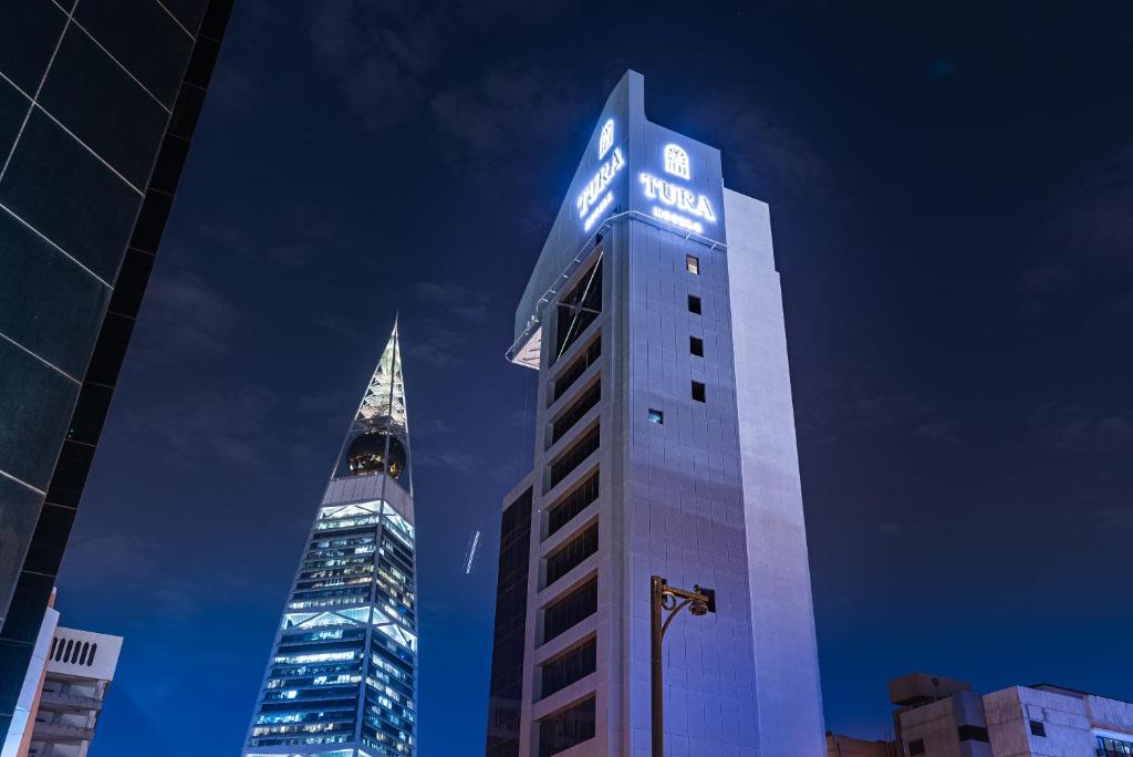 ein hohes Gebäude mit einem Schild an der Seite in der Unterkunft Tura Hotel in Riad